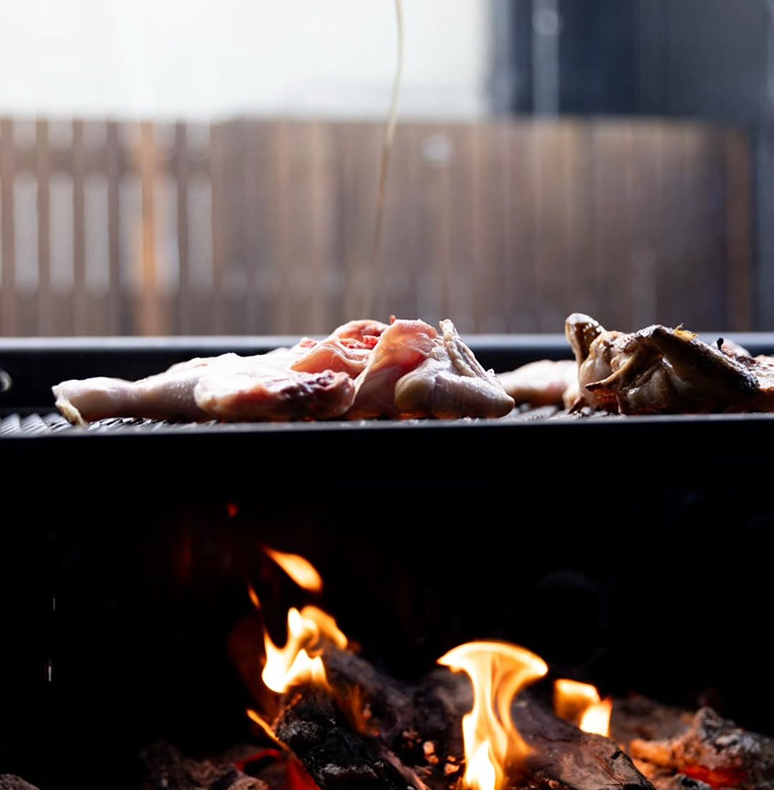 Chicken being cooked over fire at offside dining