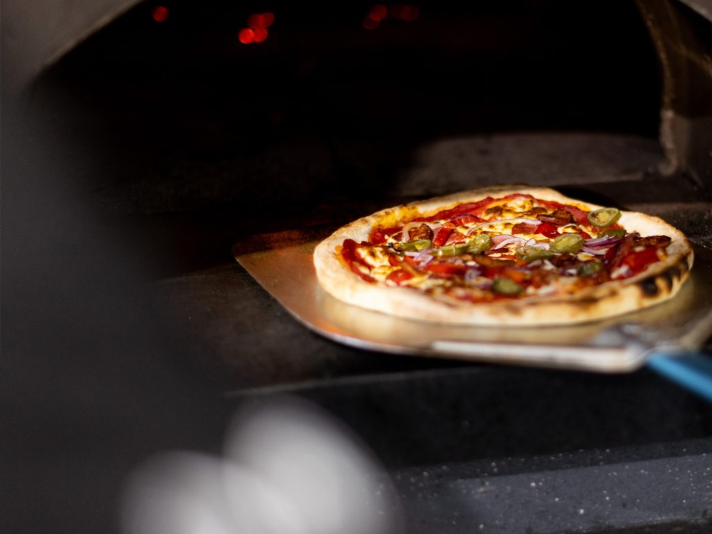Pizza coming out of the wood fire oven